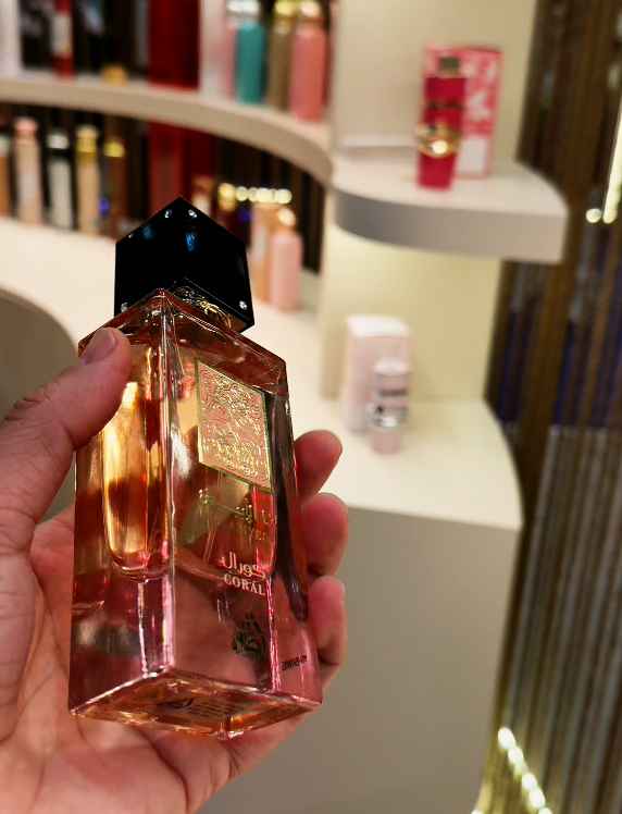 Lattafa Ana Abiyedh Coral frasco sostenido en mano en uso real