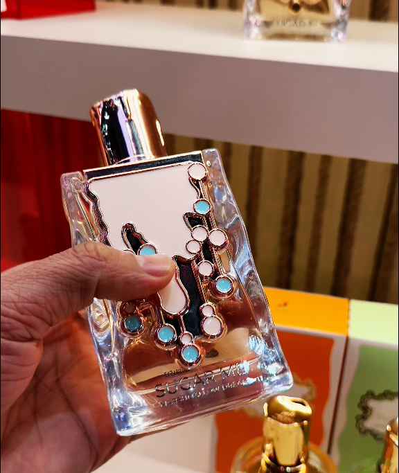 Maison Alhambra Sugar Me Marshmallow Dream perfume junto a modelo femenina en ambiente cálido