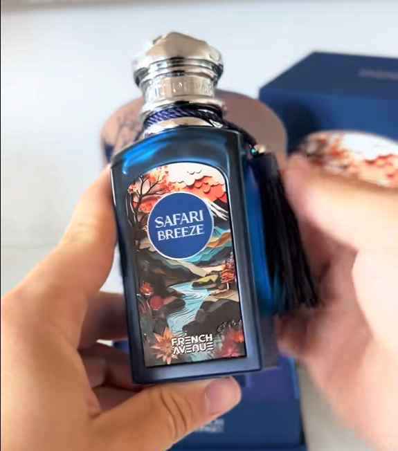 French Avenue Safari Breeze frasco sostenido en la mano en uso cotidiano