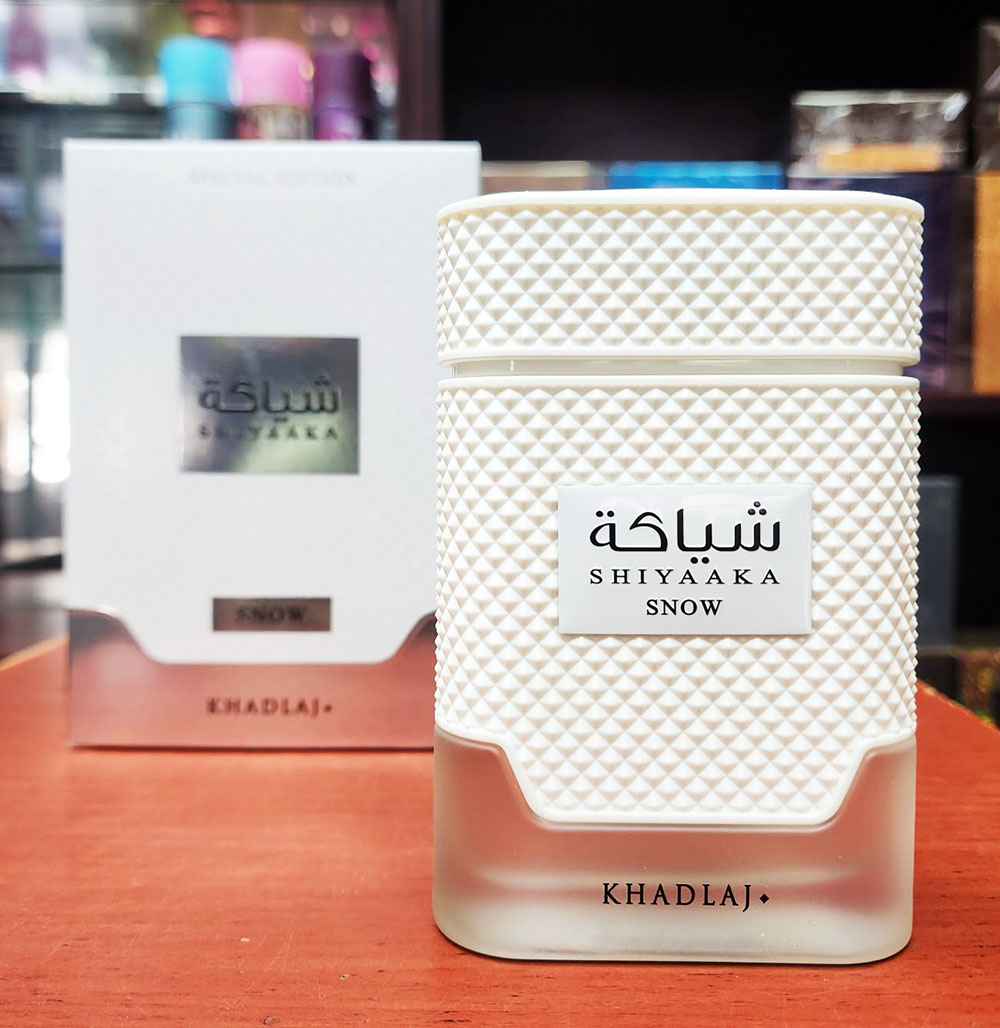 Khadlaj Shiyaaka Snow frasco y caja colocados sobre mesa en composición real