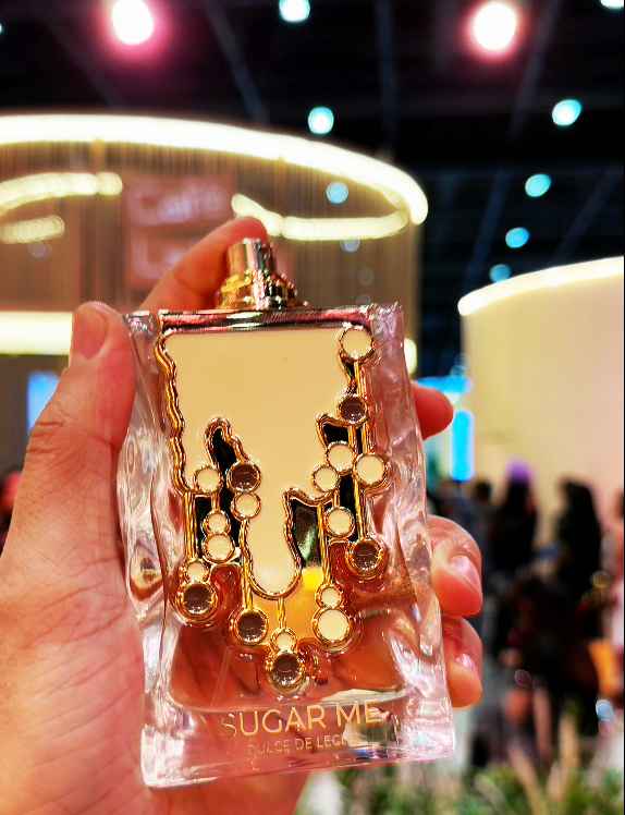 Maison Alhambra Sugar Me Dulce de Leche perfume en escena lifestyle con modelo y ambiente cálido