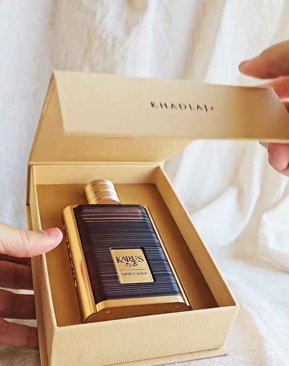 Khadlaj Karus Amber Gold colocado sobre mesa junto a su caja abierta