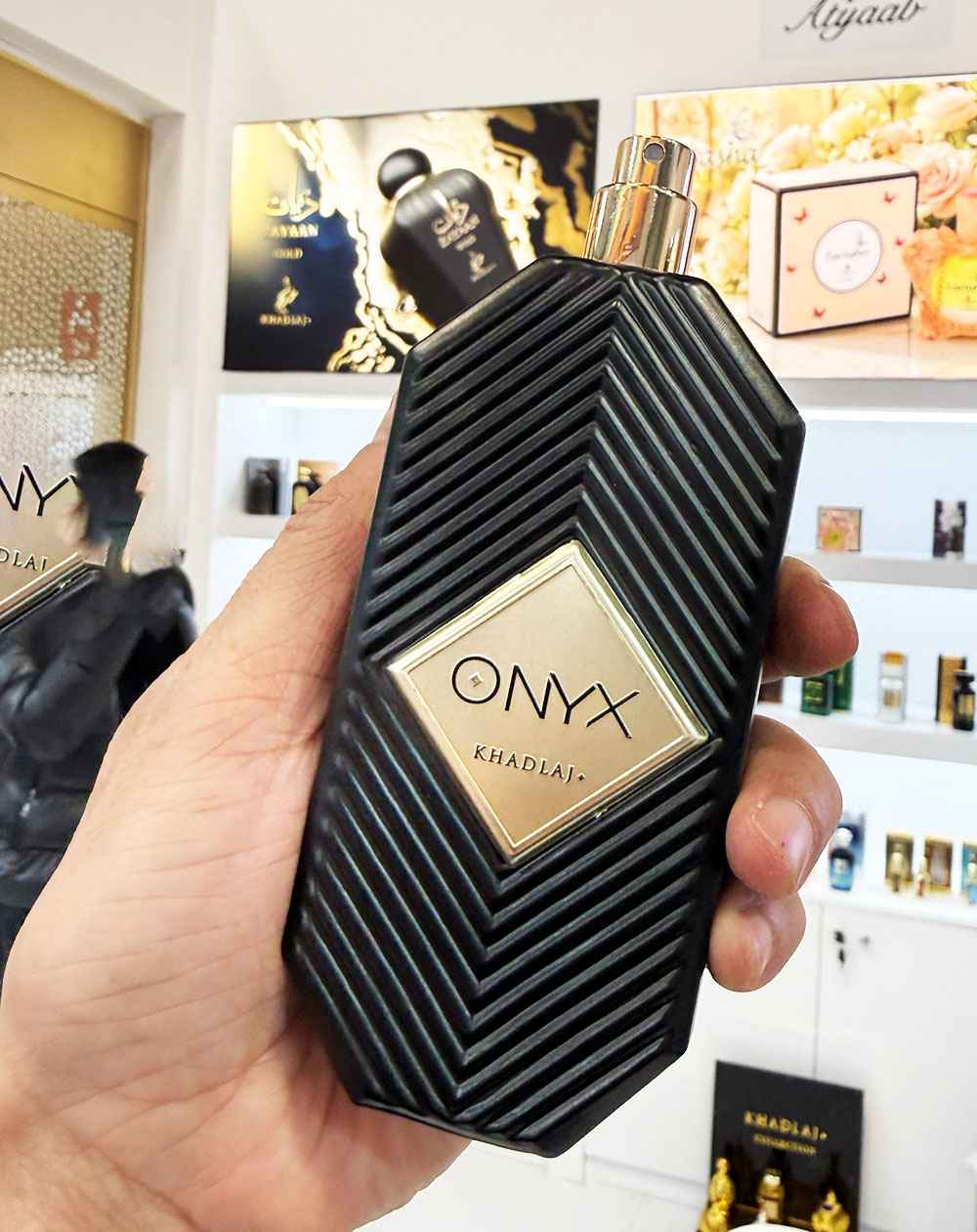 Khadlaj Onyx uso real en mano mostrando tamaño del frasco y acabado del cristal