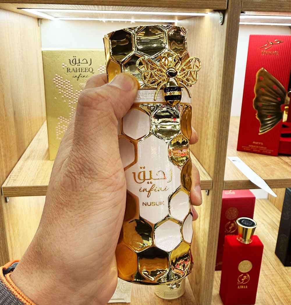 Detalle del perfume Raheeq Infini Nusuk en mano mostrando diseño elegante