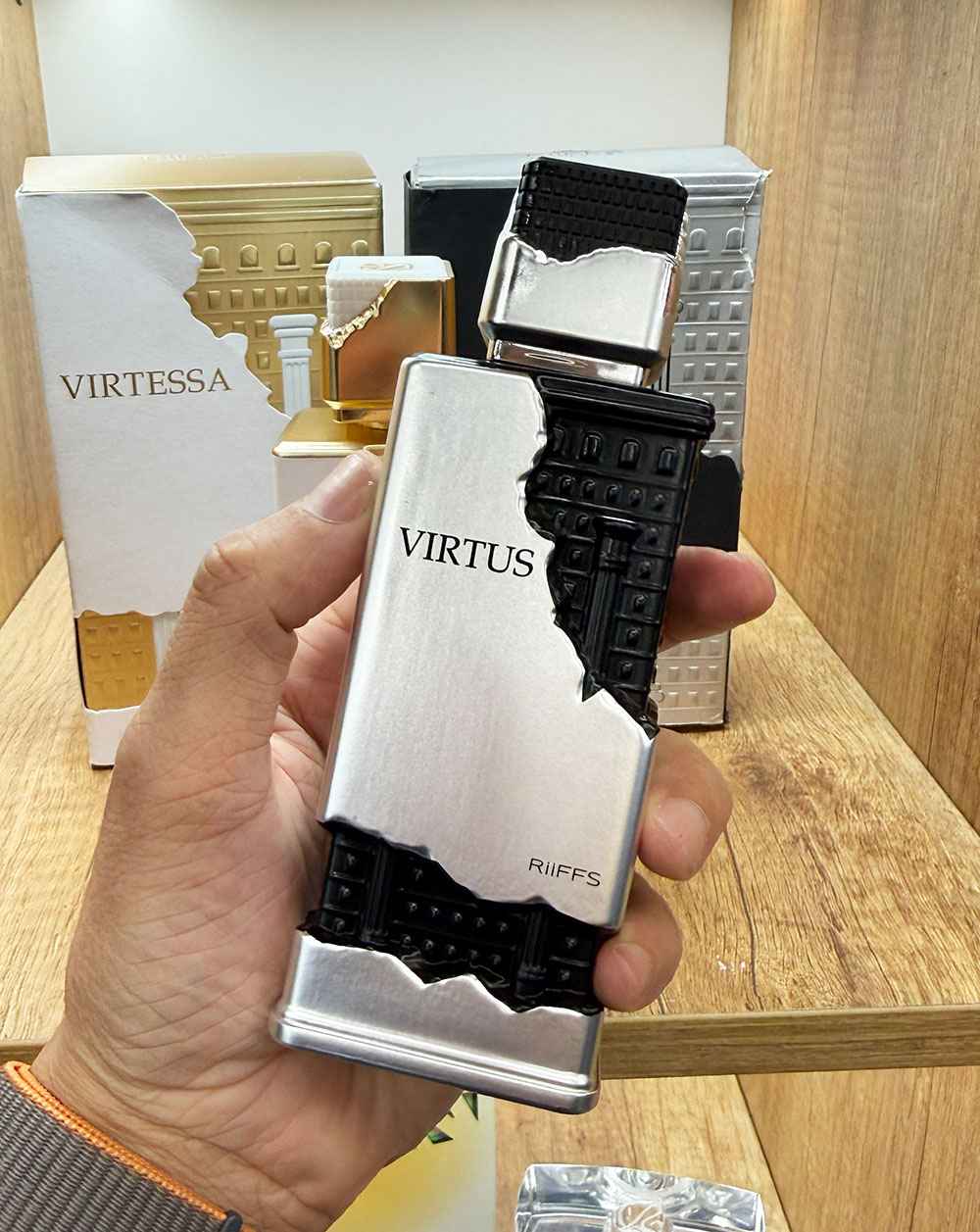 Detalle del perfume Virtus Riiffs en mano mostrando diseño moderno