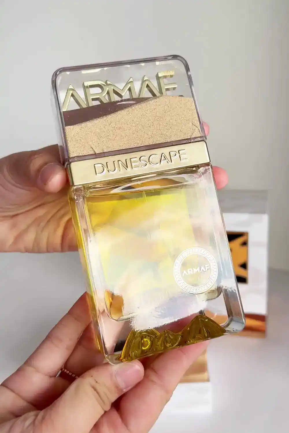 Frasco Armaf Dunescape centrado sobre fondo blanco con reflejo suave