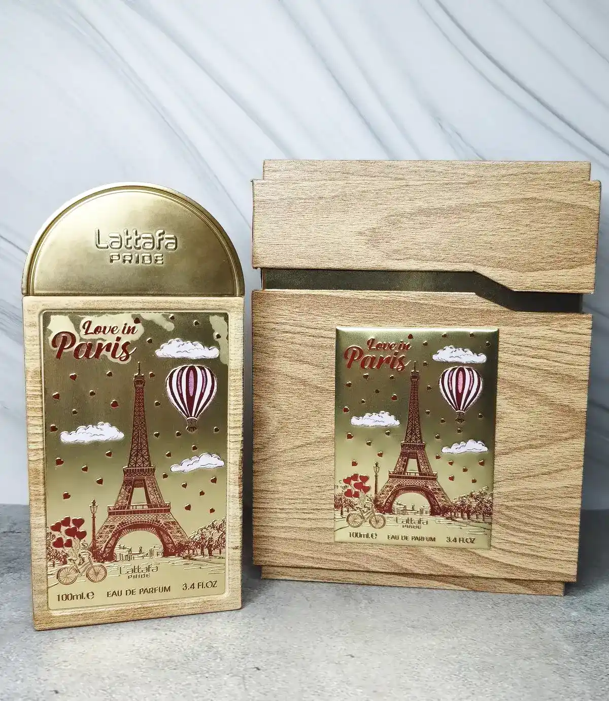 Presentación premium de Lattafa Pride Love in Paris sobre superficie de mármol cálido.