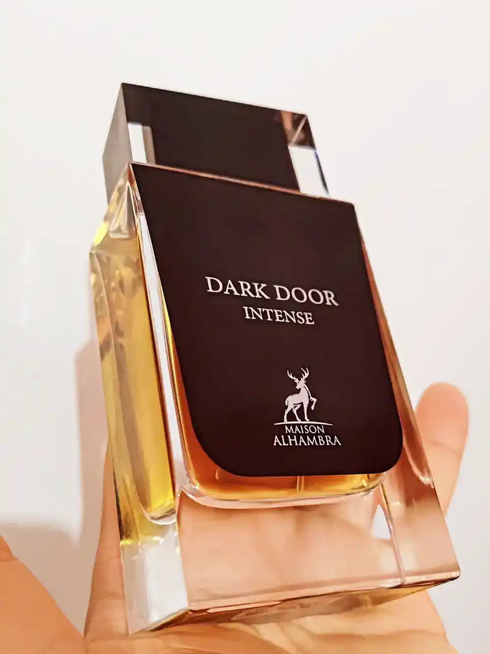 Frasco Maison Alhambra Dark Door Intense sobre fondo blanco con sombra suave